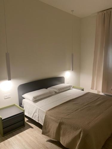 a bedroom with a large bed and two lights on at  
