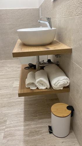 a bathroom with a sink and towels on a shelf at  