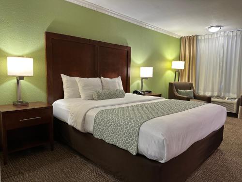 a hotel room with a large bed and a chair at The Hills Inn Eagle Rock - Near Old Town Pasadena in Los Angeles