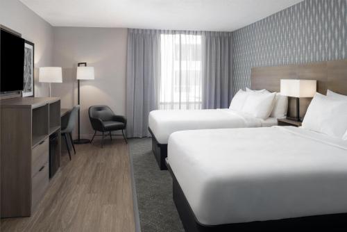 a hotel room with two beds and a television at The Midtown Hotel MOD Collection by Sonesta in Boston