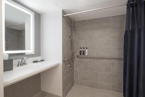 a bathroom with a shower with a sink and a mirror at The Midtown Hotel MOD Collection by Sonesta in Boston
