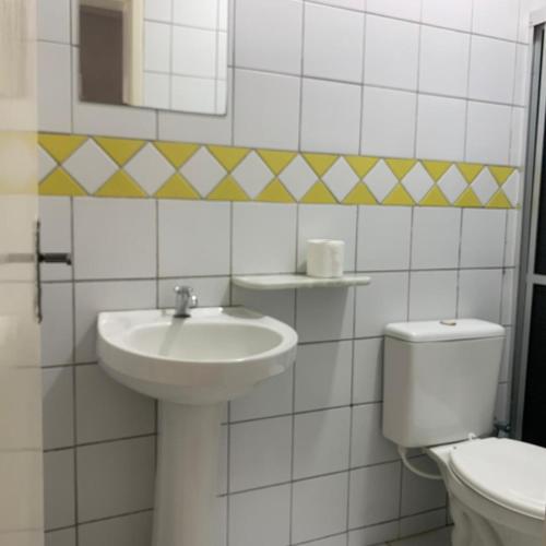 a white bathroom with a sink and a toilet at Pousada Mayer in Paulo Afonso