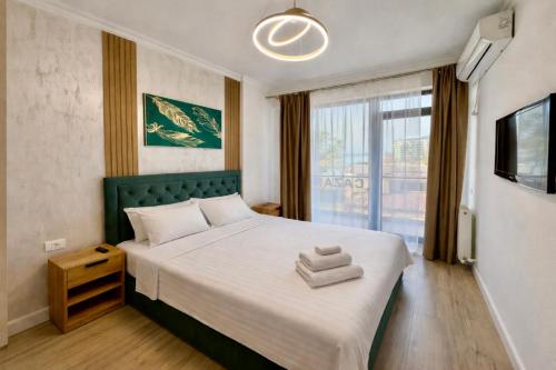 a bedroom with a large bed and a window at Solid Residence Apartamente in Mamaia