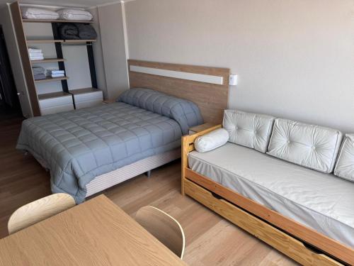 a small room with a bed and a couch at MONOAMBIENTE EDIFICIO OCEANO NECOCHEA frente al mar, in Necochea