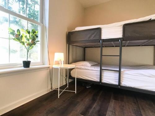 a bedroom with a bunk bed with a table and a window at HotTub|Sauna|Theater|BBQ|Firepit|Game|Pool in Long Pond