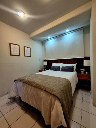 a bedroom with a large bed with a large window at Downtown Suite Wifi in Morelia