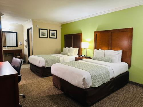 a hotel room with two beds and a desk at The Hills Inn Eagle Rock - Near Old Town Pasadena in Los Angeles