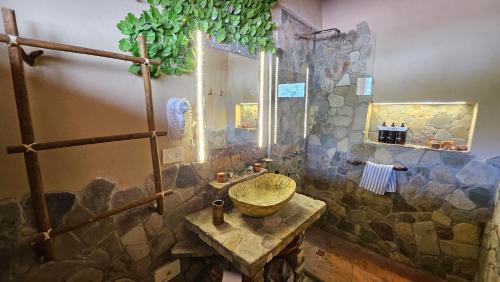 a bathroom with a sink and a stone wall at La Posada del Rio in Tilcara
