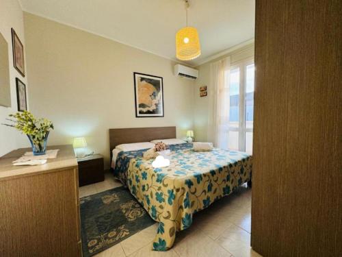 a bedroom with a bed and a desk and a window at Casa vacanza "Orchidea" in Marzamemi