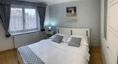 a bedroom with a white bed with two pillows at Dům na jihu Valtice in Valtice