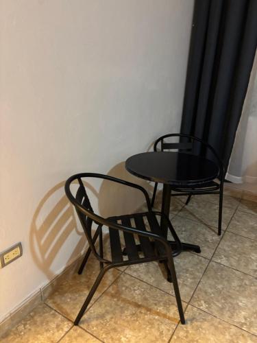 two chairs and a table in a room at Habitación Roble, cómoda y espaciosa in Saltillo