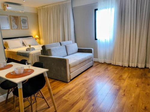 a bedroom with a bed and a table and a couch at Flat Hotel Merc Espaçoso Ibirapuera 4 estrelas com Wi-Fi Recepção 24 horas 3PRI in São Paulo