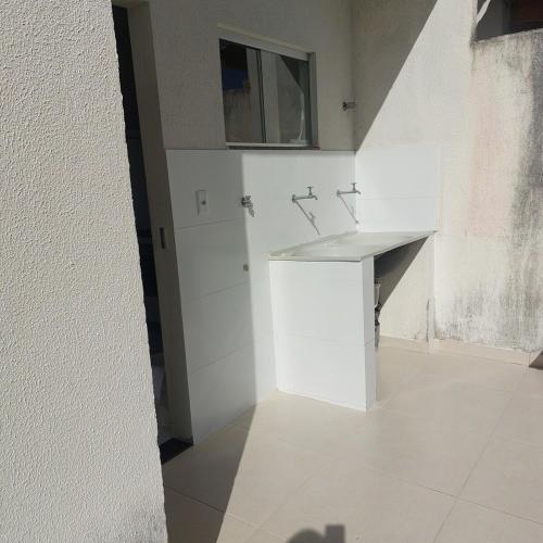a white bathroom with a sink in a room at Descanso Paz e sossego com muito aconchego in Prado