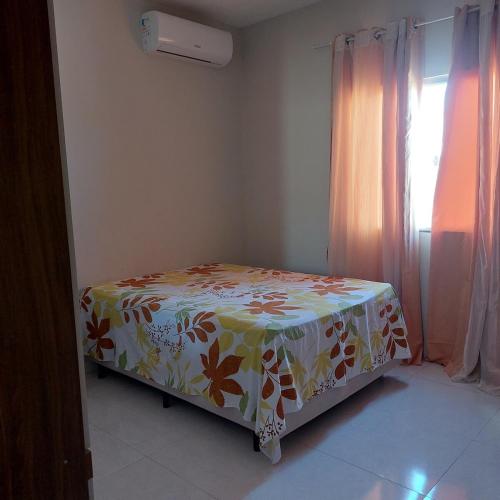 a small bed in a room with a flowered sheet at Descanso Paz e sossego com muito aconchego in Prado