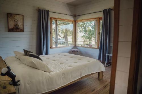 a bedroom with a large bed in a room with windows at Casa en Las Perdices, Carmelo in Carmelo