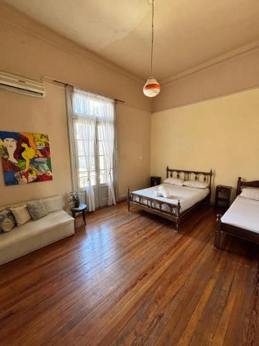 a large room with two beds and a couch at Colmena Hostel Rosario in Rosario