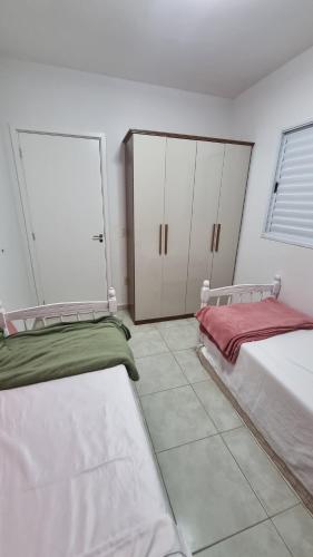 two beds in a room with white cabinets at Casa Holambra Van den Broek in Holambra