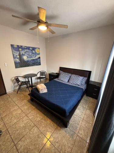 a bedroom with a blue bed and a table at Habitacion Arboleda in Saltillo