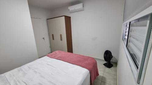 a small white room with a bed and a window at Casa Holambra Van den Broek in Holambra