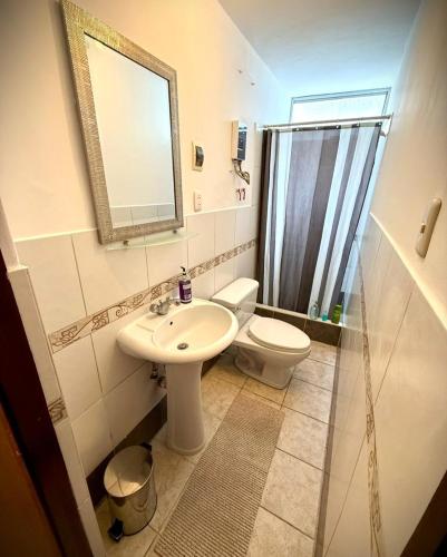 a bathroom with a sink and a toilet and a mirror at Ocean Blue in Huanchaco