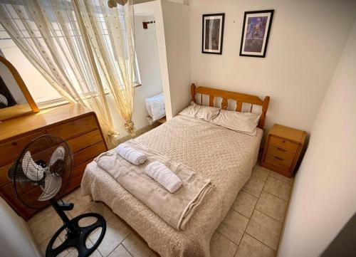 a bedroom with a bed with a fan and a window at Ocean Blue in Huanchaco