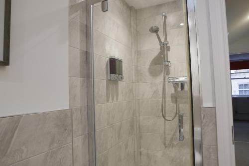 a bathroom with a shower with a glass door at Converted Coastal Coach House in Weston-super-Mare