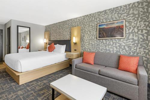 a hotel room with a bed and a couch at Best Western Montrose Inn in Montrose