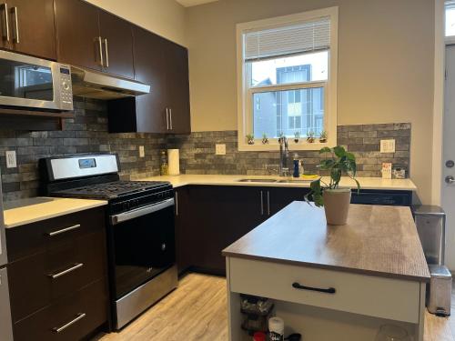 a kitchen with brown cabinets and a stove top oven at Sunlit Haven in Calgary