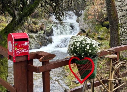 a heart on a fence next to a waterfall at Moinho de Brião in Montalegre