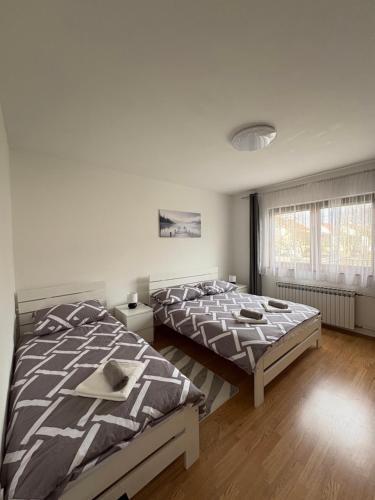 a bedroom with two beds and a window at Apartment OrMarić in Otočac