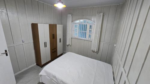a small bedroom with a bed and a window at Casa da vó cida in Itapoa