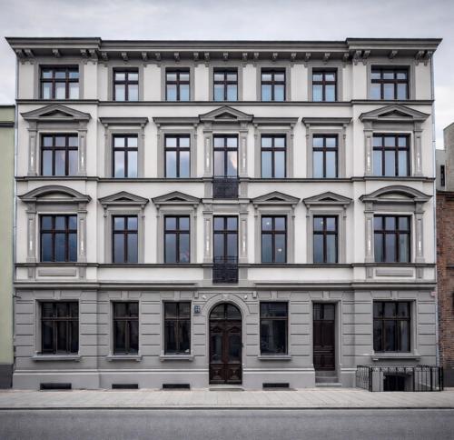 a white building with black windows and a door at Modern Apartments Toruń 1 Stare Miasto-Centrum in Toruń