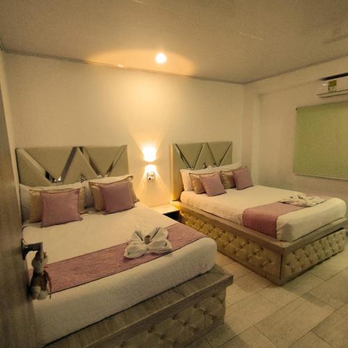 two beds in a room with a green board at Hotel Aquamarina Maicao in Maicao
