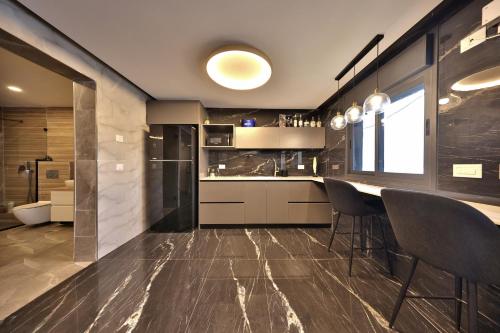 a kitchen with a bar and some chairs in it at סוויטות חוף האהבה in Haifa