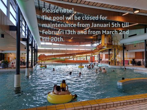 a large swimming pool with people in the water at Boshuisje op de Schatberg in Sevenum