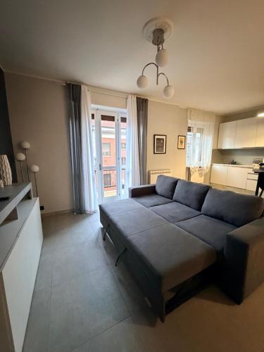 a living room with a blue couch and a kitchen at Ladybug in Canale