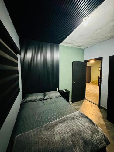 a bedroom with a bed with a black wall at Departamento Mateos 501 in Ciudad Acuña