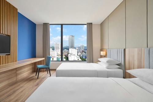 a hotel room with two beds and a window at Four Points by Sheraton Nha Trang in Nha Trang