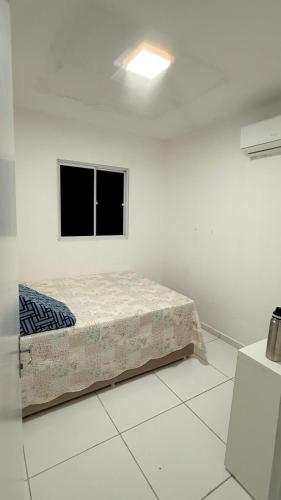a bed in a white room with a window at Casa condominio Reserva do Delta 07 in Parnaíba
