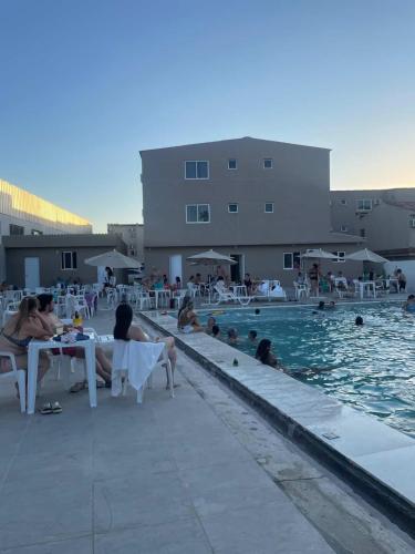 a group of people sitting around a swimming pool at Marechal Plaza Hotel in São Gabriel