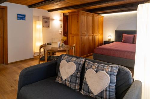 a bedroom with a bed and a couch with two hearts at MANY'S historical city central APARTMENTS in Zurich