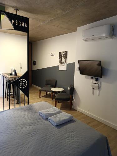 a bedroom with a bed and a tv and a table at ANDÉN by FMA Coliving in Salta