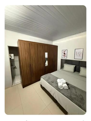 a bedroom with a large bed and a wooden cabinet at Casa da Vila de São Jorge in Sao Jorge