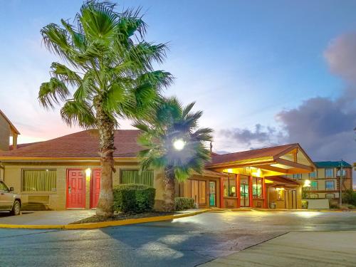 a building with two palm trees in front of it at Travelodge by Wyndham Houston Hobby Airport in Houston