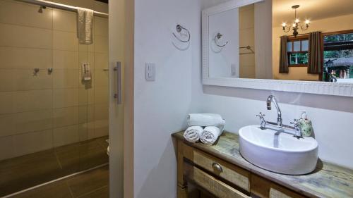 a bathroom with a sink and a mirror at Hotel Britannia in Penedo