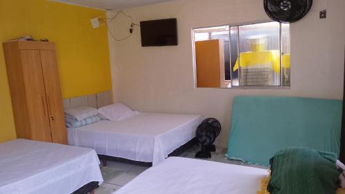 a room with two beds and a window at Chalé a beira mar ilhéus in Ilhéus