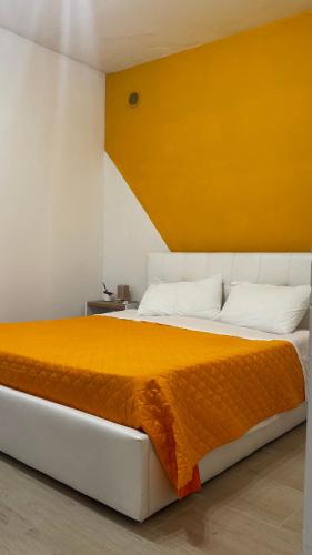 a bedroom with a large bed with a yellow headboard at Lumèra Holiday Home in Pizzo