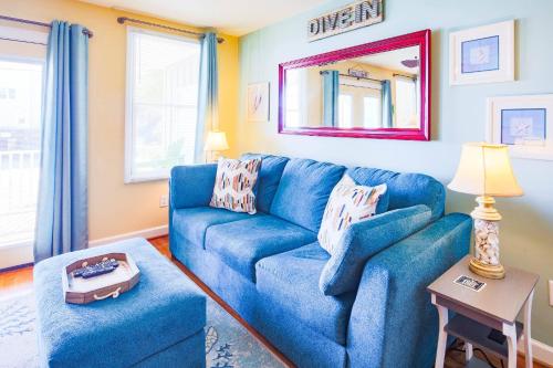 a living room with a blue couch and a table at Hang 6 in Folly Beach