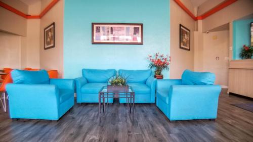 a waiting room with blue couches and a table at Travelodge by Wyndham Houston Hobby Airport in Houston
