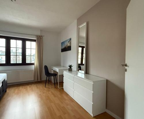 a bedroom with a desk and a bed and a mirror at Ferienwohnung in der Innenstadt in Euskirchen